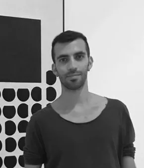 Andrea Veramonti in bianco e nero, davanti a un pannello con un rettangolo nero e una griglia di forme tonde